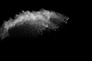 White powder explosion cloud against black background.White dust particles splash.