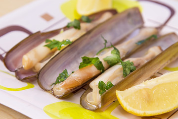 knives cooked on the grill with green sauce