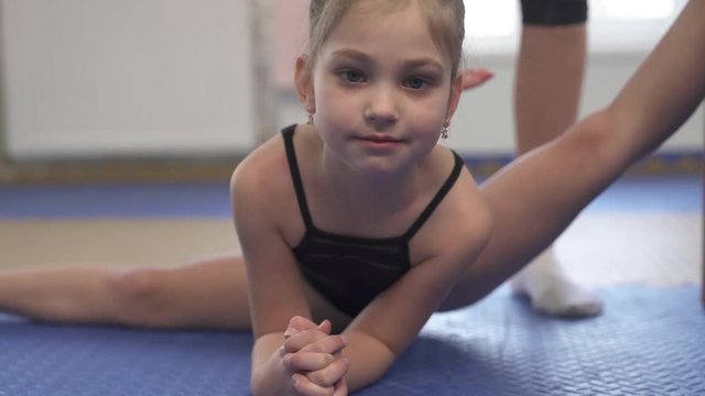 A demonstration video of a professional gymnast performing the heel stretch. Professional sport routine concept