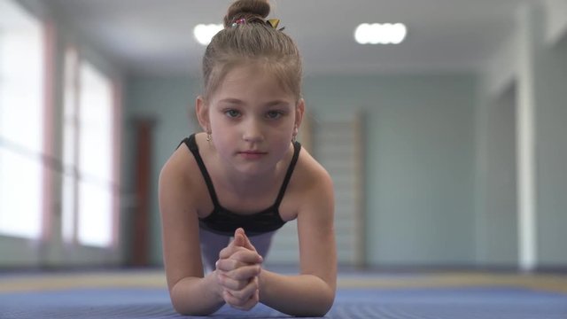 A close-up of a professional child doing fitness or gymnastic exercises (plank exercise).