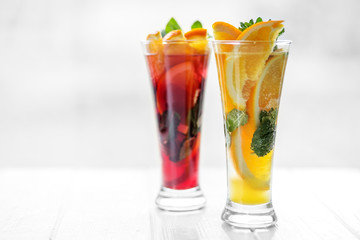 Refreshing healthy cocktails with mint and citrus and pomegranate on a white background. Concept for drinks, summer, heat, alcohol, party and bar