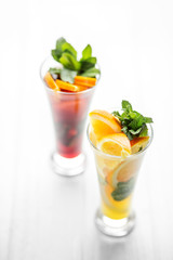Refreshing healthy drinks with mint and citrus and pomegranate on a white background. Concept for drinks, summer, heat, alcohol, party and bar
