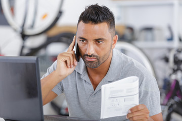 man on the phone fixing a bike