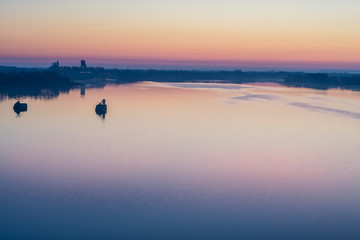 Scenic sunset over the calm water surface.