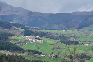 Fototapeta na wymiar Beautiful landscape with mountain, green fields and rural village in the Basque Country, Spain. The little Swiss