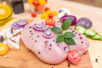 Raw chicken fillet and vegetables prepared for cooking on the kitchen.