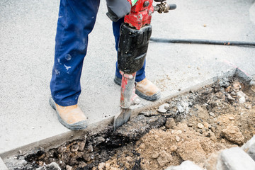ouvrier remettant à niveau les pavés sur le bord de la route