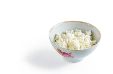 Fresh cottage cheese in white bowl on white background