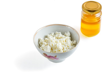 Cottage cheese in white bowl and honey