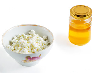 Cottage cheese in white bowl and honeyon white background