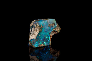 Macro stone Opal mineral in rock on a black background close up