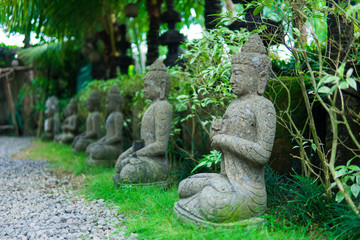 Obraz premium Stone religious sculpture covered by green moss in Goa Gajah Sanctuary. Bali, Indonesia