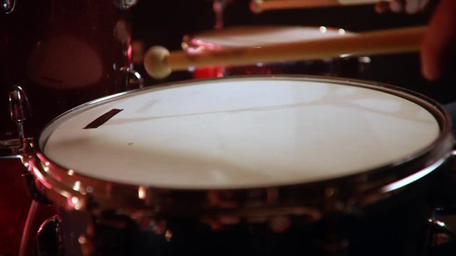 drummer, jazz lesson , percussion drumsticks , slow drumroll on a snare a rehearsal studio on a red drums , low key, close-up