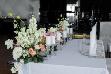 newlyweds table in restaurant decoration fresh flowers and candles. Wedding fresh flowers decoration