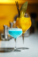 Alcoholic cocktail in a glass goblet on the bar counter.