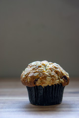 Whole grain muffin on wooden background.