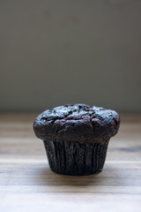 Chocolate muffin on wooden background.