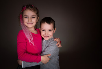 Boy and girl look to the camera in studio