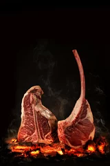 Foto op Canvas Whole T-Bone steak cooking on embers. Black background. © Volodymyr Shcerbak