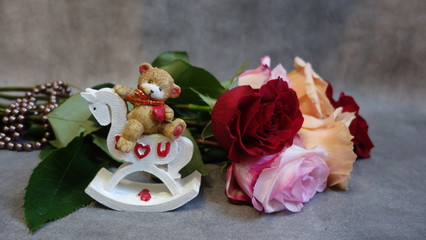 a bouquet of roses and a bear on a horse