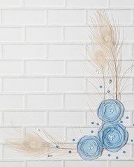 Light Blue Vertical Background With Handmade Gentle White Ranunculus Flowers and Peacock Feathers, Lying Flat, Top View. Have an Empty Place For Your Text.