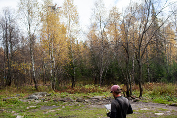 Male tourist exploring new places. Handsome bearded man on nature with fuel. Using drone...
