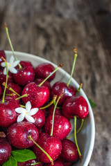Bowl of fresh red cherries on wooden background, close up,  vertical composition - Image