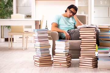 Male student with many books at home 