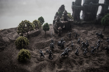 Medieval battle scene with cavalry and infantry. Silhouettes of figures as separate objects, fight between warriors on sunset foggy background.