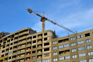 Large construction site with cranes on the blue sky background. Construction worker truss installation - Image