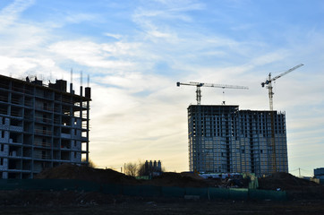 Construction crane on the construction site on the background of sunset, sunrise.