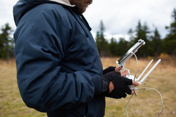 Male tourist exploring new places. Handsome bearded man on nature with fuel. Using drone photographs and shoots nature