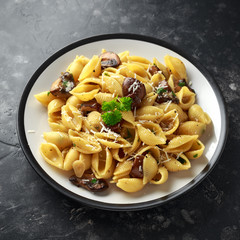 Conchiglie pasta with mushrooms, creamy sauce, parmesan cheese and herbs
