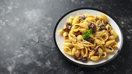 Conchiglie pasta with mushrooms, creamy sauce, parmesan cheese and herbs