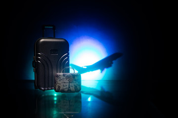 stack of traveling luggage in airport terminal and passenger plane flying over sky