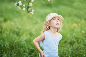 Girl collects dandelions bouquet for a wreath in meadow of orhard