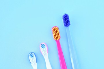 Plastic personal toothbrush for dental health care on blue background. Family toothbrushes concept on neutral backdrop. Children's and adult toothbrushes for daily dental hygiene