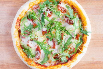 Pizza with dried tomatoes, arugula and mozzarella on a gray-blue dark background with copy space