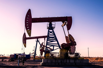 Oil pumps are running in the sunset at the oil field. On the Bohai coast of China.