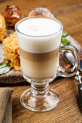A glass of delicious latte on wooden table.