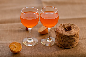 two glasses of orange juice,two slices of lemon and a Bay of twine