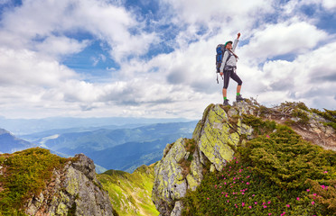 successful young woman backpacker open arms on mountain peak - obrazy, fototapety, plakaty