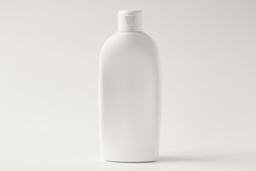 White plastic bottle for cream on a white background. Front view.