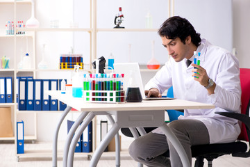 Young handsome chemist working in the lab 