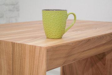 green mug standing on a wooden table
