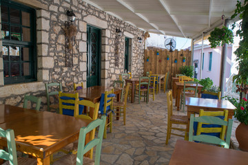 Traditional old Greek cafe tavern with blue doors and chairs on sidewalk,Lefkada, Greece