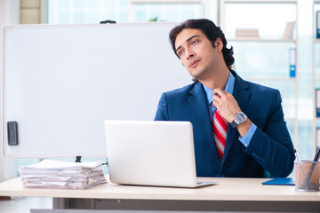 Young handsome businessman in front of whiteboard 