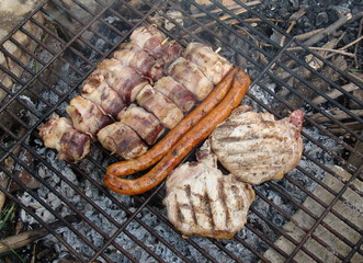 Difefrent kind of meat on grille / grid, sausages, bacon, cutlets