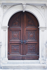 Arched wooden door with white stone surrond