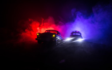 Police car chasing a car at night with fog background. 911 Emergency response police car speeding...